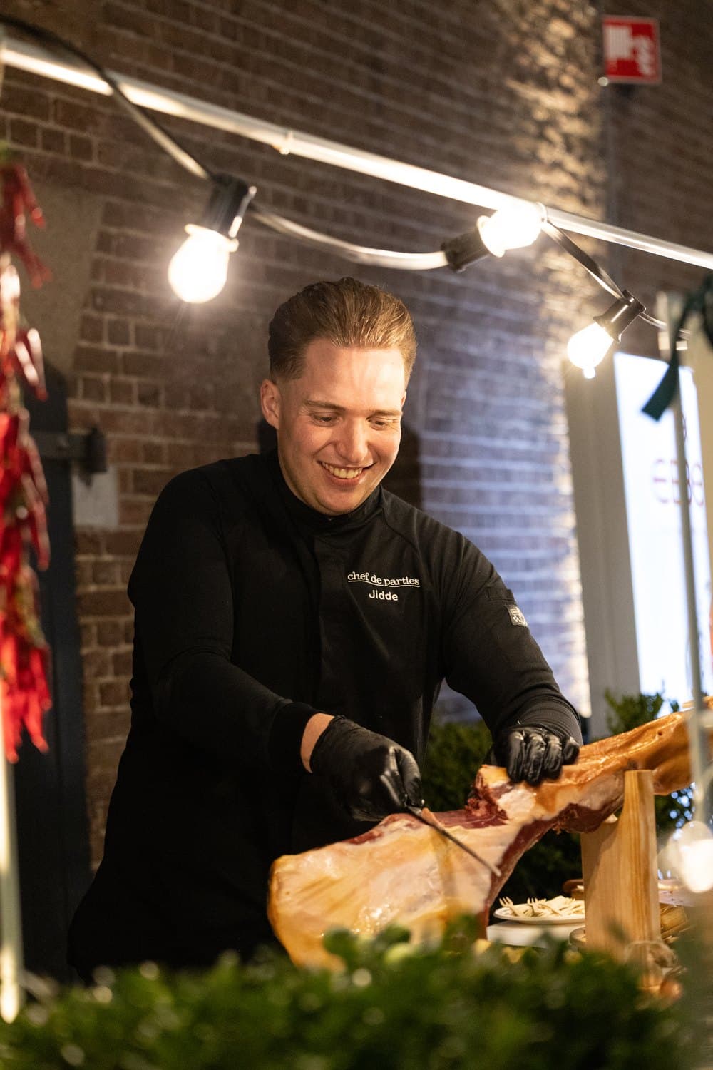 Chef snijdt iberico ham aan de verlichte stand