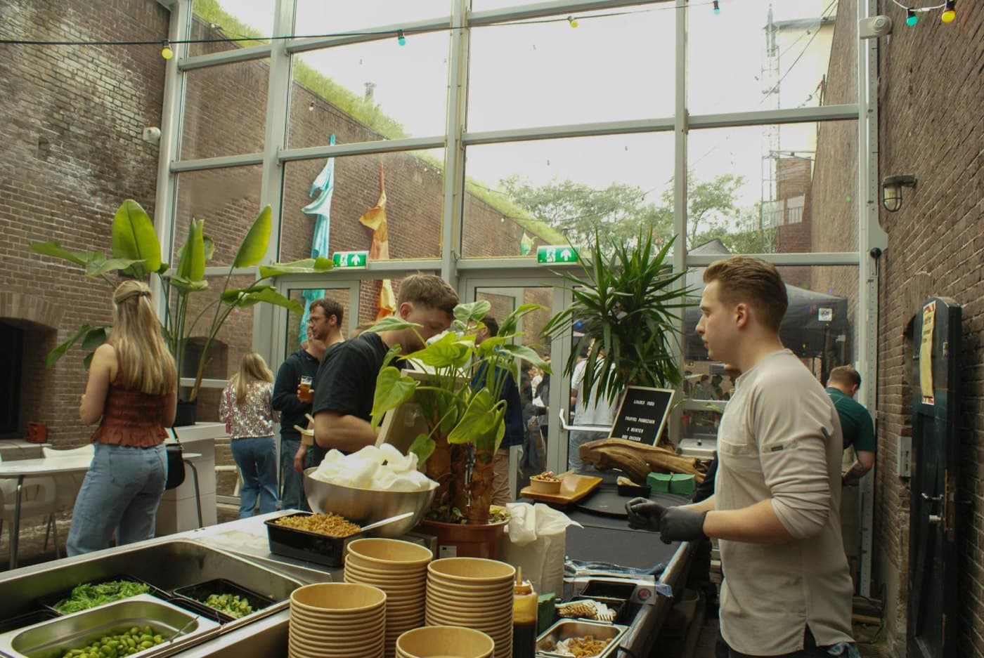 Guests gathering around the live cooking stations in the glasshouse venue