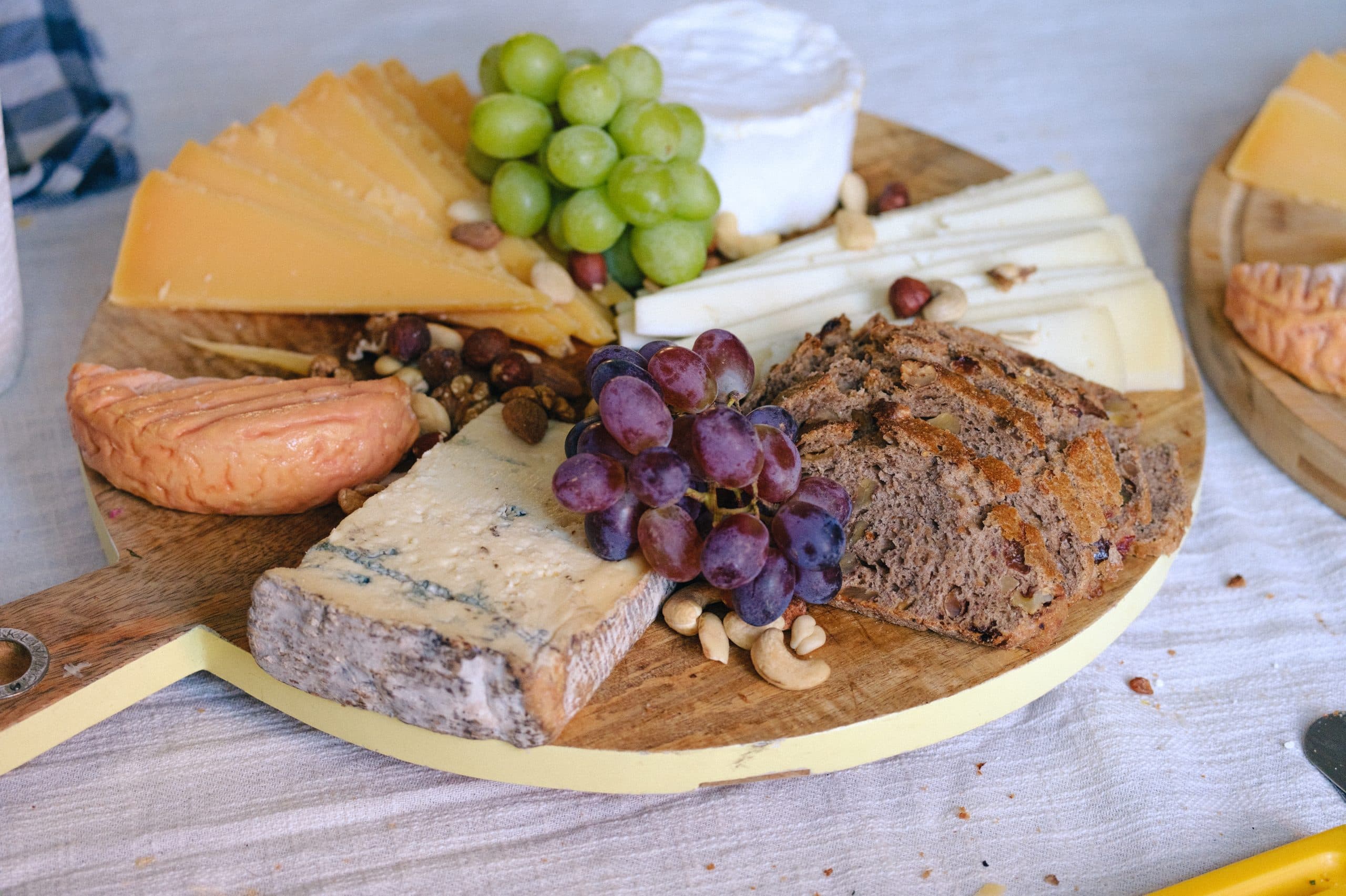 Kaasplank met oude kaas, blauwaderkaas, druiven, noten en notenbrood