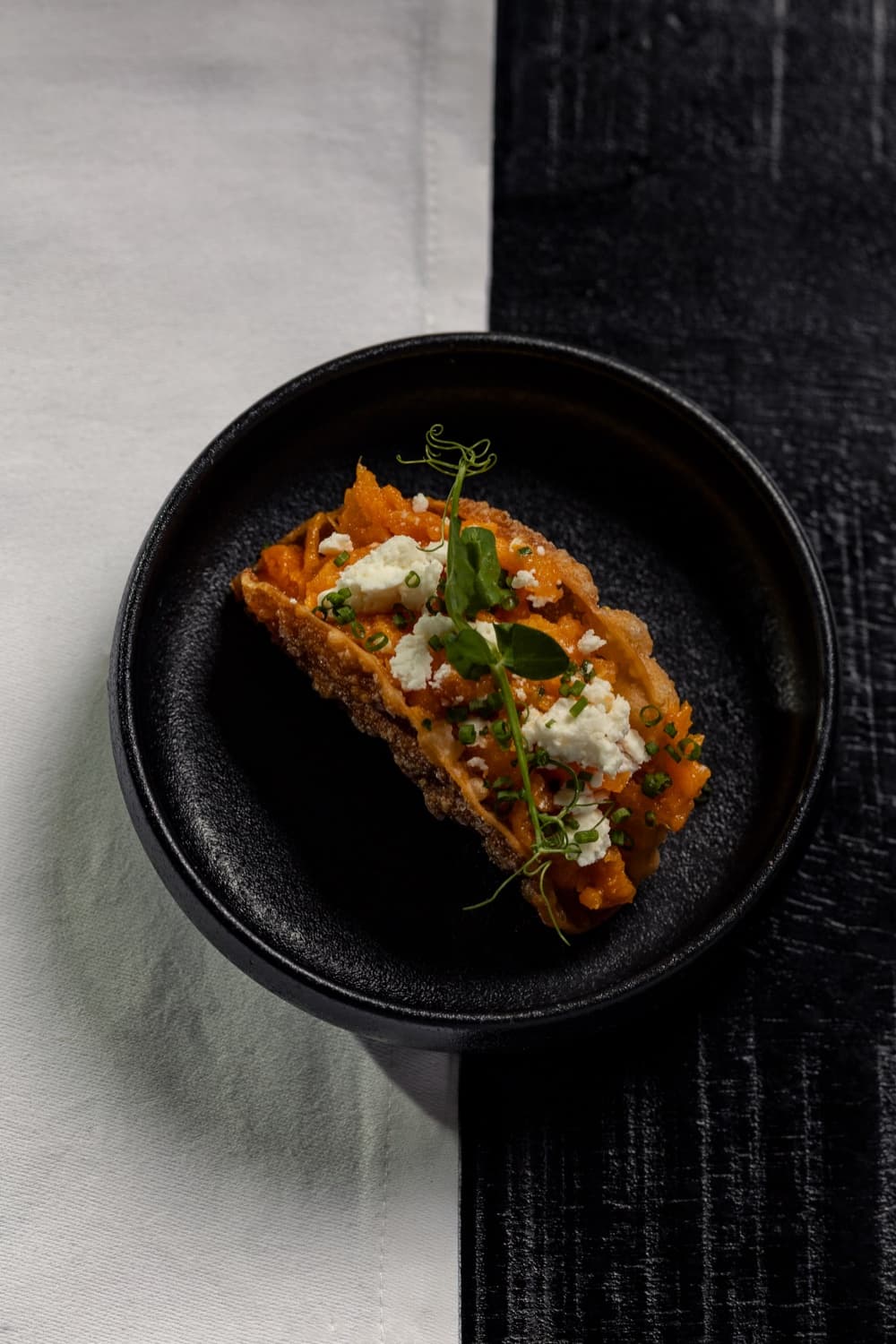 Vegetarian sweet potato and feta bite on a black plate