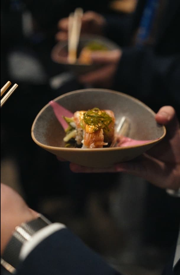 Guest tasting a sushi dish from a handmade bowl